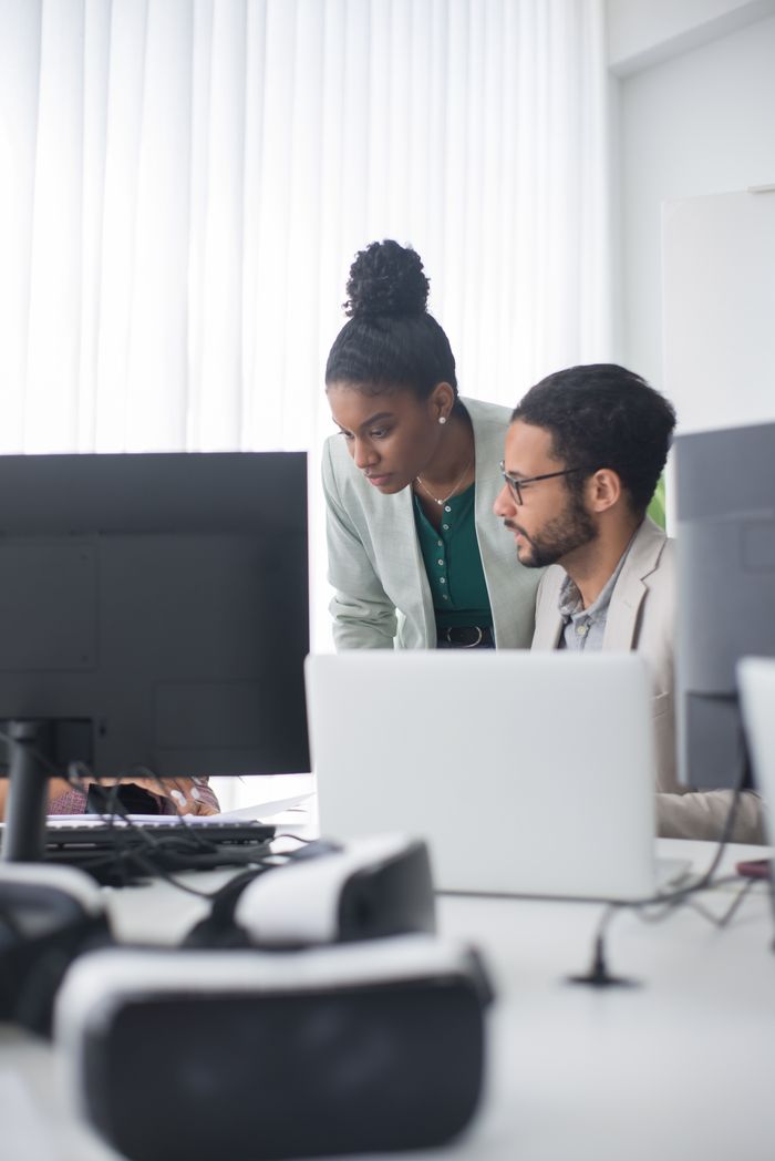 The Art of Drawing Readers In: Your attractive post title goes here Two professionals collaborate in a modern office setting, promoting teamwork and innovation.